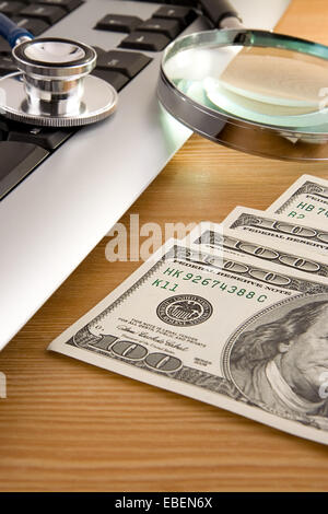 Stethoskop auf Tastatur und Dollar auf Holz Stockfoto