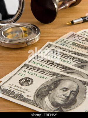 Dollar, Kompass und Sanduhr auf Holz Stockfoto