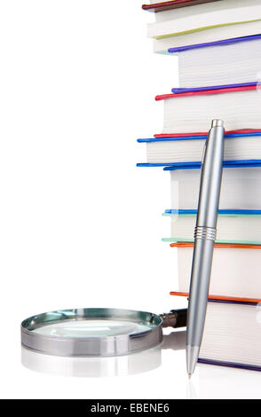 Haufen neuer Bücher, Stift und Lupe isoliert auf weißem Hintergrund Stockfoto
