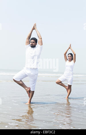 indische paar Strand Yoga Stockfoto