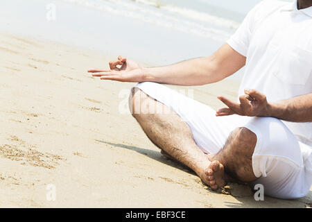 indischer Mann Strand Yoga Padmasana Stockfoto