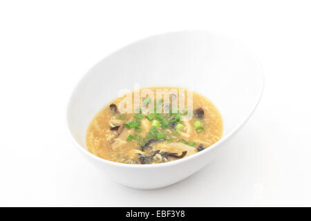 Eine Schüssel mit heißem und saure Suppe isoliert auf einem weißen Hintergrund. Stockfoto