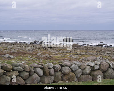 Ein schwarzer Tag mit Herbst oder Winter stürmen auf Jæren, westlich der norwegischen Küste in der Nähe von Stavanger Wellen brechen über Steinen und Strand Stockfoto