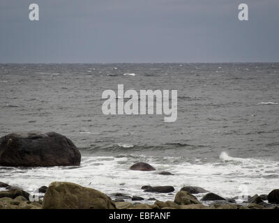 Ein schwarzer Tag mit Herbst oder Winter stürmen auf Jæren, westlich der norwegischen Küste in der Nähe von Stavanger Wellen brechen über Steinen und Strand Stockfoto