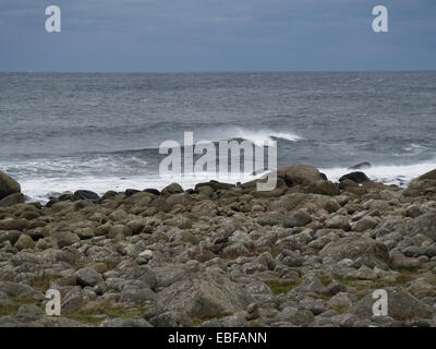 Ein schwarzer Tag mit Herbst oder Winter stürmen auf Jæren, westlich der norwegischen Küste in der Nähe von Stavanger Wellen brechen über Steinen und Strand Stockfoto