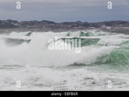 Herbst oder Winter Stürme auf Jæren, westlich der norwegischen Küste in der Nähe von Stavanger Wellen brechen über Strand, Dorf Brusand hinter Stockfoto