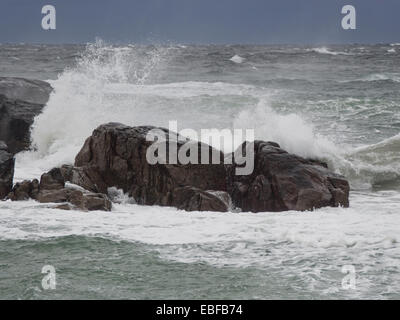 Ein schwarzer Tag mit Herbst oder Winter stürmen auf Jæren, westlich der norwegischen Küste in der Nähe von Stavanger Wellen brechen über Felsen und Strand Stockfoto