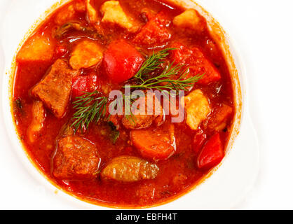 Gulaschsuppe im Suppenteller auf weißem Hintergrund Stockfoto