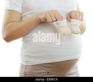 Schwangere Frau mit Stiefeletten in Händen Nahaufnahme. Isoliert auf weiss. Stockfoto