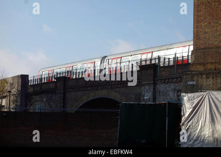 Der Londoner Tube trainieren sich nähernden Latimer Road u-Bahnstation mit Züge oberirdischen zwischen den Gebäuden. Stockfoto