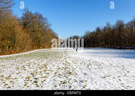 Menschen wandern im Winterschnee wie Turm auf dem Anwesen von Stourhead, Wiltshire Somerset Grenze, Vereinigtes Königreich. Stockfoto