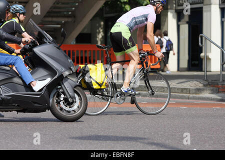 Radfahrer und Biker fahren entlang einer Straße in London. Stockfoto