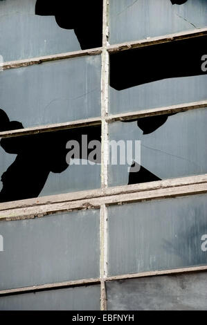 Zerbrochene Fensterscheiben aus einem alten Industriegebäude Stockfoto
