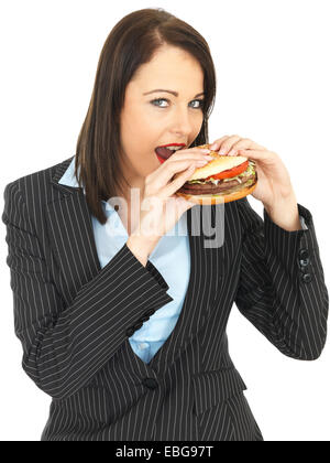 Attraktive Geschäftsfrau, die einen Rindfleischburger Essen Stockfoto