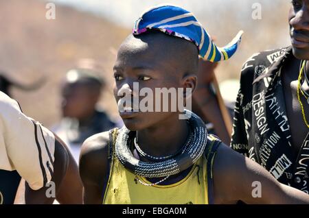 Himba junge Mann trägt eine traditionelle Kopfbedeckung, Kappe in Form eines Horns Rinder, Omohanja, Kaokoland, Kunene, Namibia Stockfoto