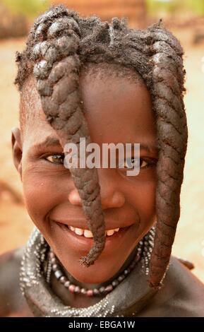 Lächelnde Himba-Mädchen mit typische Frisur, Omuramba, Kaokoland, Kunene, Namibia Stockfoto