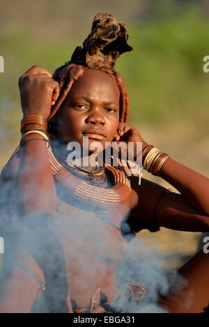 Himba junge Frau am Lagerfeuer, Ombombo, Kaokoland, Kunene, Namibia Stockfoto