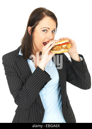 Attraktive Geschäftsfrau, die einen Chicken Burger essen Stockfoto