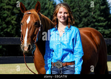 41,857.09283 junge Frau in einem blauen Ruf durch ihr Bucht Pferd in Nahaufnahme Stockfoto