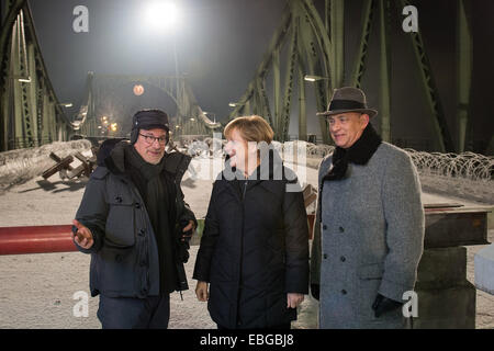 Eine Handout Bild zur Verfügung gestellt von der Bundesregierung zeigt (L-R) US-Regisseur Steven Spielberg, Bundeskanzlerin Angela Merkel und US Schauspieler/Darsteller Tom Hanks am Set von Spielbergs neuer Spion Thriller "St. James Place" (Arbeitstitel) an der Glienicker Brücke in Potsdam, Deutschland, 28. November 2014. Die Brücke zwischen den ehemaligen kommunistischen DDR Teil Berlins und den westlichen Alliierten Zonen nannte sich "Agentenbrücke" durch amerikanische und sowjetische Gefangene Austausch über es in den Jahren des Kalten Krieges zwischen 1962 und 1986. EPA/GUIDO BERGMANN/HANDOUT HANDOUT ZUR REDAKTIONELLEN VERWENDUNG NUR/KEIN VERKAUF Stockfoto