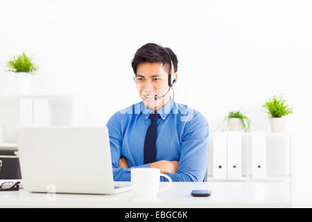 lächelnde Geschäftsmann tragen ein Kopfhörer im Büro Stockfoto