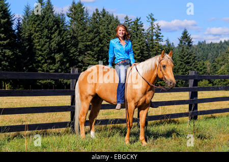 41,857.09385 Mädchen sitzen ohne Sattel und stützte sich zurück auf Palomino Pferd Stockfoto