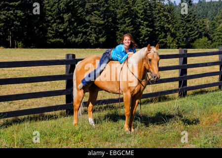 41,857.09397 junges Mädchen liegend ohne Sattel auf dem Rücken eines Pferdes palomino Stockfoto