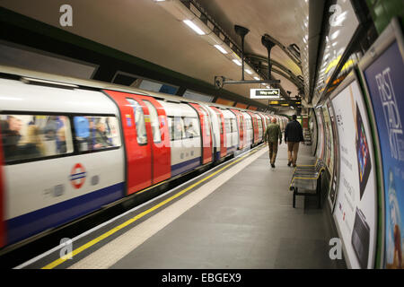 zwei Männer zu Fuß entlang der Plattform als eine Northern Line der London Underground Station verlässt Stockfoto