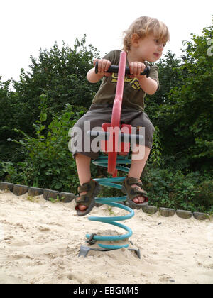 kleiner Junge am Springer auf dem Spielplatz Stockfoto