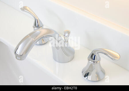 Waschbecken im Badezimmer und Zähler: Nahaufnahme eines Badezimmer Waschbecken, Chromhahn und weiße Theke. Stockfoto