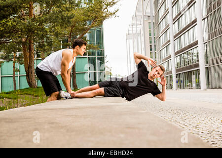 Personal Trainer dabei im freien Training in städtischen Platz, München, Bayern, Deutschland Stockfoto