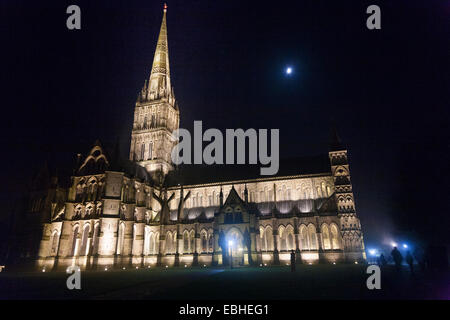 Kathedrale von Salisbury in Dunkelheit mit Flutlicht / Dunkelheit in der Nacht in der Nacht mit Mond, während der Herbst / Winter. Salisbury. UK Stockfoto
