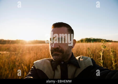 Selbstporträt von Bauer im Weizenfeld bei Sonnenuntergang, Plattsburg, Missouri, USA Stockfoto