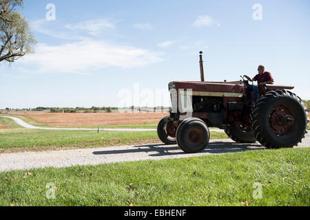 Landwirt Traktor zu fahren, auf der Landstraße, Missouri, USA Stockfoto