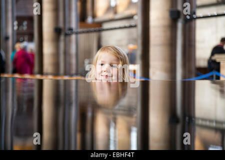 4 vier Jahre jungen Mädchen Gesicht Reflektion / Reflexion / reflektieren in der Schriftart "lebendiges Wasser". Salisbury Kathedrale Wiltshire UK