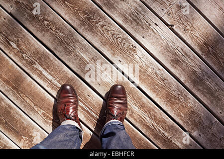 Selbstporträt von reifer Mann der Beine und Füße auf Holzboden Stockfoto