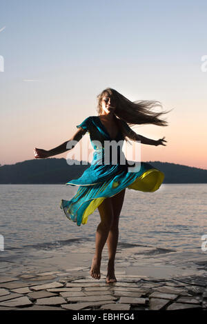 Junge Frau drehte sich um am Meer bei Sonnenuntergang, Milna, Brac, Kroatien Stockfoto