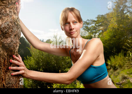 Weibliche Läufer gelehnt Rock im Park Aufwärmen Stockfoto