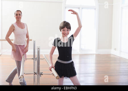 Mädchen üben Ballett mit Lehrer an der Barre in der Ballettschule Stockfoto