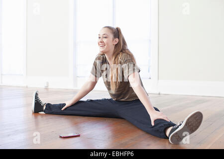 Teenager-Mädchen Aufwärmen und dabei den Spagat in der Ballettschule Stockfoto