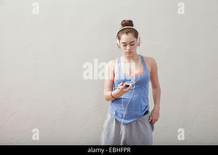 Teenager-Mädchen Smartphone Musikhören im Ballett-Schule Stockfoto