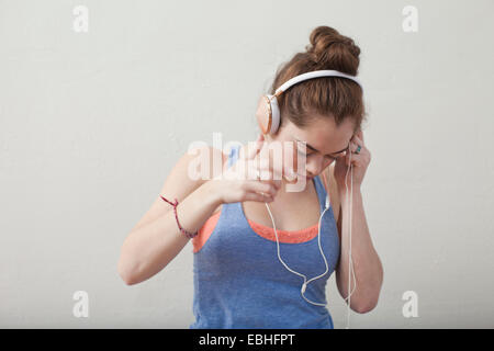 Teenager-Mädchen hören über Kopfhörer in der Ballettschule Stockfoto