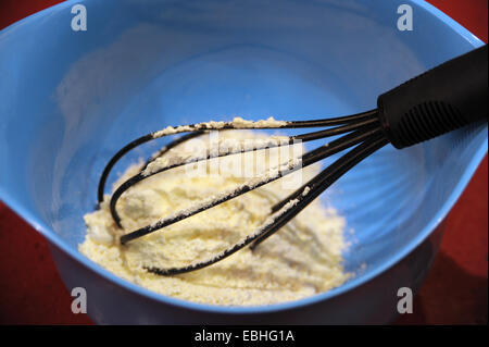 Schüssel mit einem Schneebesen und Zutaten Stockfoto