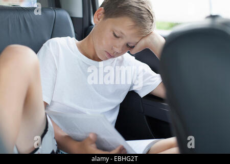 Teenager Rücklesen Sitz des Auto Stockfoto