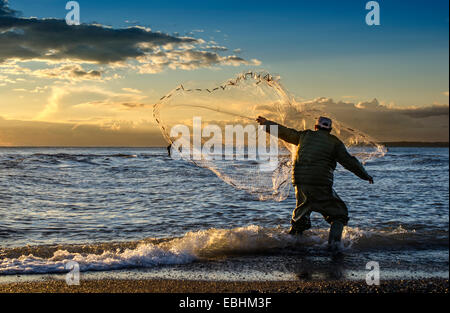 Die Fischer werfen Fischernetz während des Sonnenuntergangs in Griechenland Stockfoto