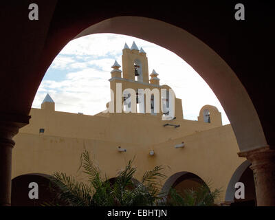 Iglesia de San Roque Church Glocken aus betrachtet die unter einem Bogen im Hof des Kulturinstituts, Campeche, Mexiko Stockfoto