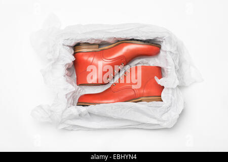 neue rote Schuhe in Box mit Geschenkpapier Stockfoto