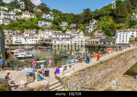 Ein Panoramablick auf die Landschaft Sommerblick auf den Hafen von Polperro mit Einheimischen und Touristen, die einen sonnigen hellen Tag genießen, Cornwall England Großbritannien Stockfoto