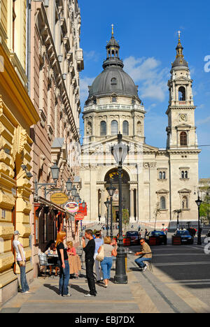 Budapest, Ungarn. St Stephen Basilika von Binnenthal Utca gesehen. Junge Leute reden außerhalb café Stockfoto