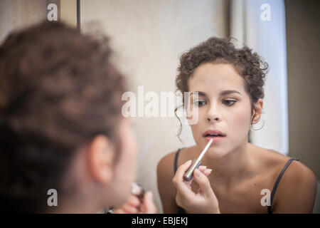 Junge Frau Anwendung Lip Gloss Stockfoto